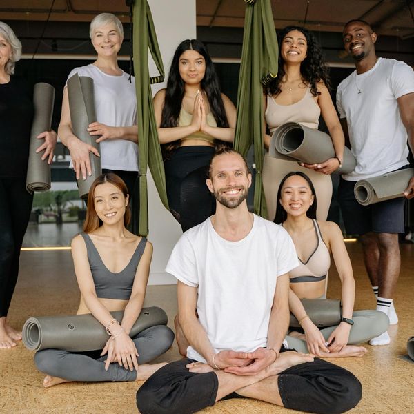 Diverse group of people smiling during a gentle yoga class.
