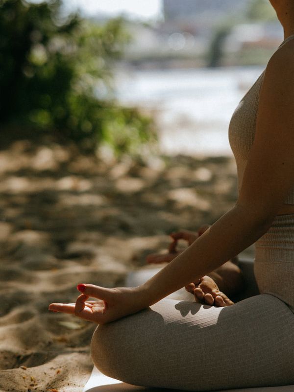 Person meditating peacefully in a serene, natural environment.